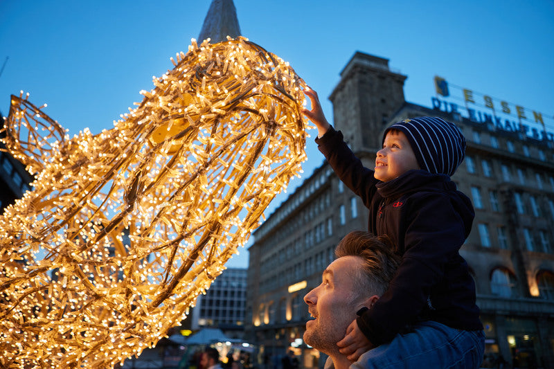 Leuchtende Lichtinstallation während der Essener Lichtwochen in der Essener Innenstadt mit Besuchern am Abend.