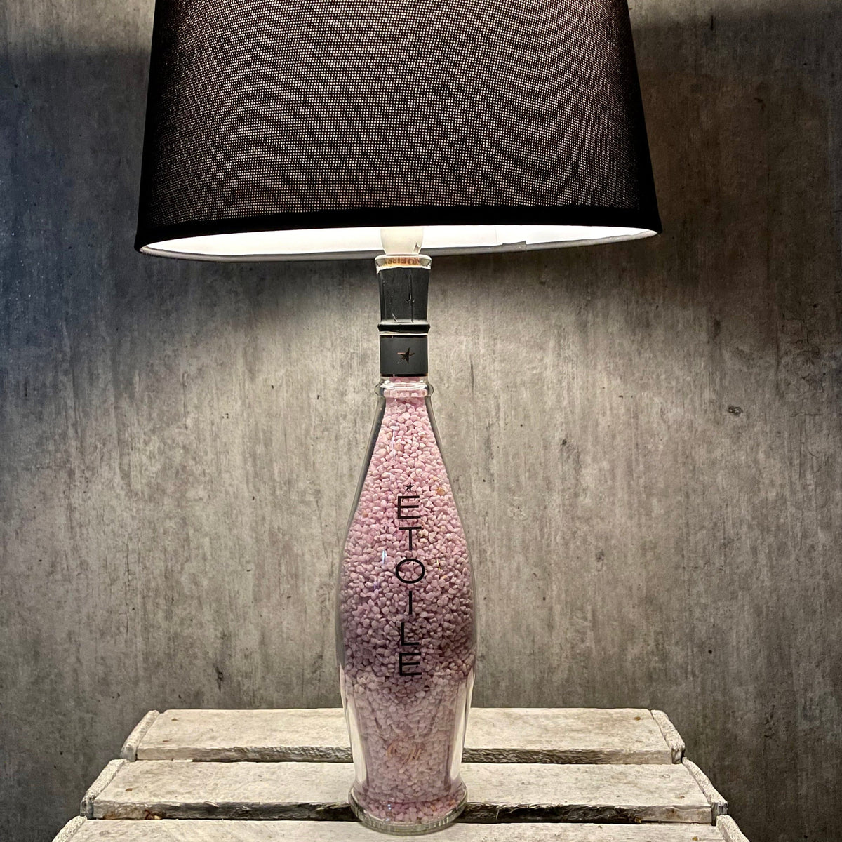 Domaines Ott Étoile 2020 Weinflaschenlampe mit dunklem Schirm auf rustikalem Holztisch