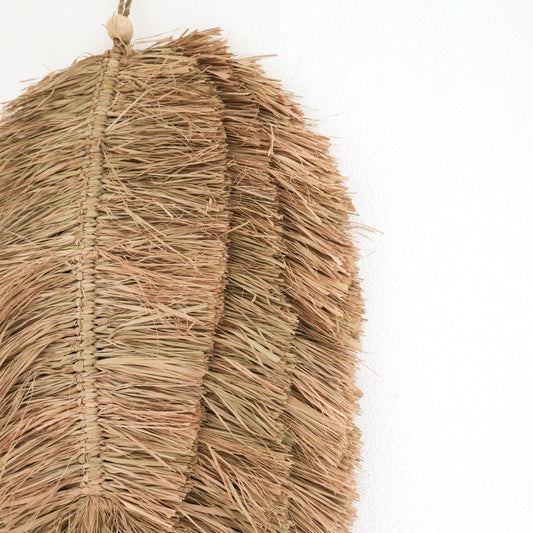Detail der Raffia-Fransen, Flechtnaht und Holzperle an der Wanddeko TIPIN