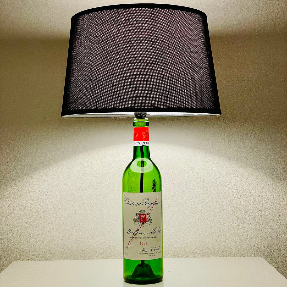 Château Poujeaux 1981 Weinflaschenlampe mit dunklem Lampenschirm auf hellem Regal