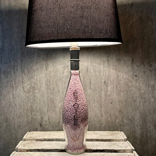 Domaines Ott Étoile 2020 Weinflaschenlampe mit dunklem Schirm auf rustikalem Holztisch