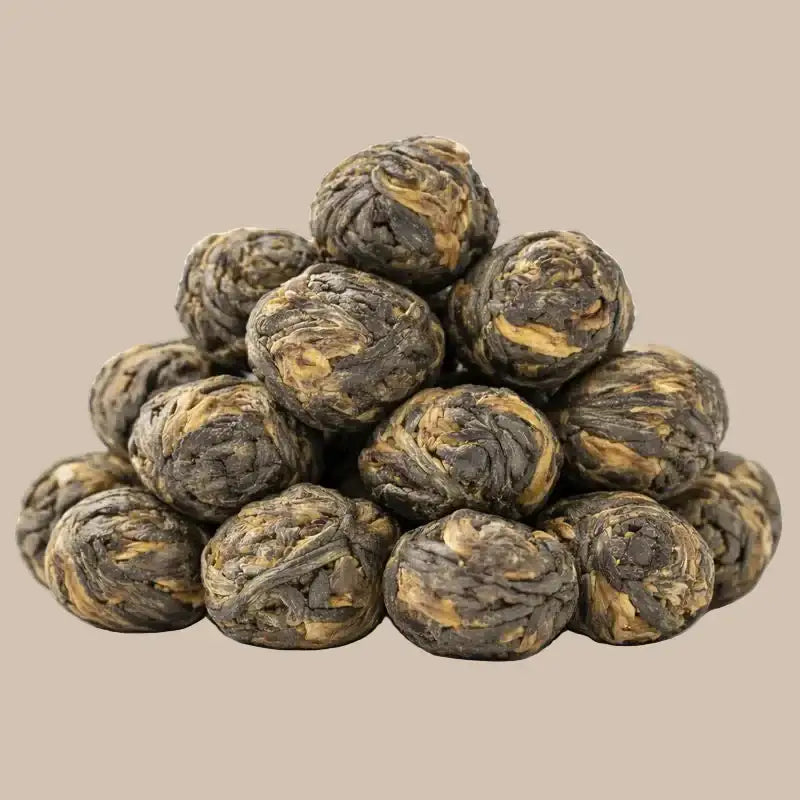 SteinKunstWerk Black Jasmine Pearls – hochwertige, handgerollte Jasmintee-Perlen im Aufguss, klar dargestellt mit sichtbarer Blattstruktur und ruhiger Präsentation