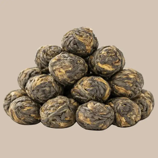 SteinKunstWerk Black Jasmine Pearls – hochwertige, handgerollte Jasmintee-Perlen im Aufguss, klar dargestellt mit sichtbarer Blattstruktur und ruhiger Präsentation