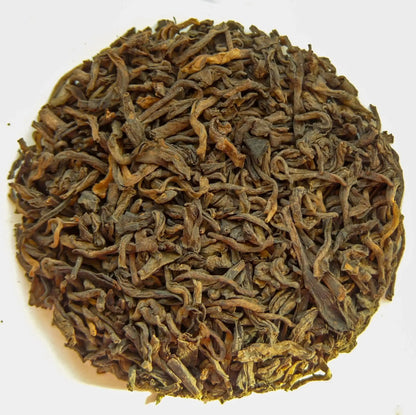 Shou Pu Erh Tee – fermentierte Teeblätter aus Yunnan, warm serviert und stimmungsvoll in Szene gesetzt.